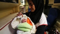 Bolničarka brine o novorođenoj bebi u Sarpol-e Zahab
