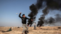Jedan palestinski demonstrant baca kamenje prema izraelskim vojnicima u Han Junusu