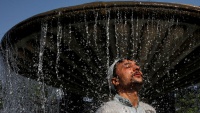 Pakistanac u Karačiju stoji pod vodom kako bi se rashladio