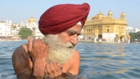 Starac Sik na vjerskoj ceremoniji na rijeci Zlatni hram u Armitsaru, u Indiji
