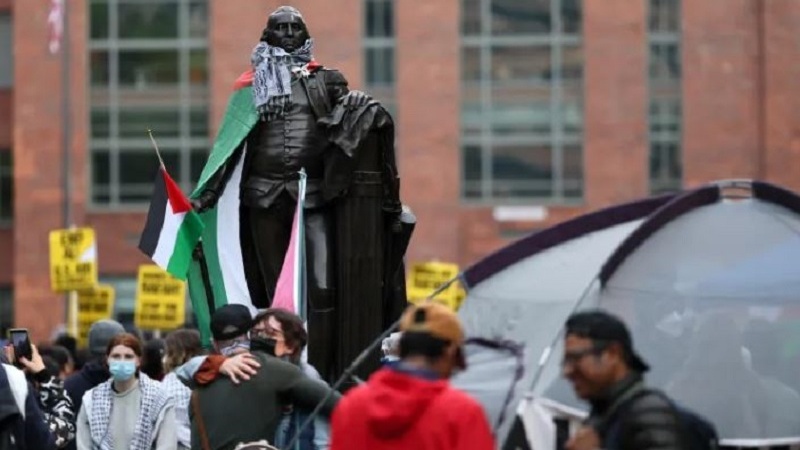 چەفیە و ئاڵای فەلەستین لە سەرشانی بناغه دانەری ئەمریکا